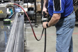 cross employee cleaning a newly fabricated hose