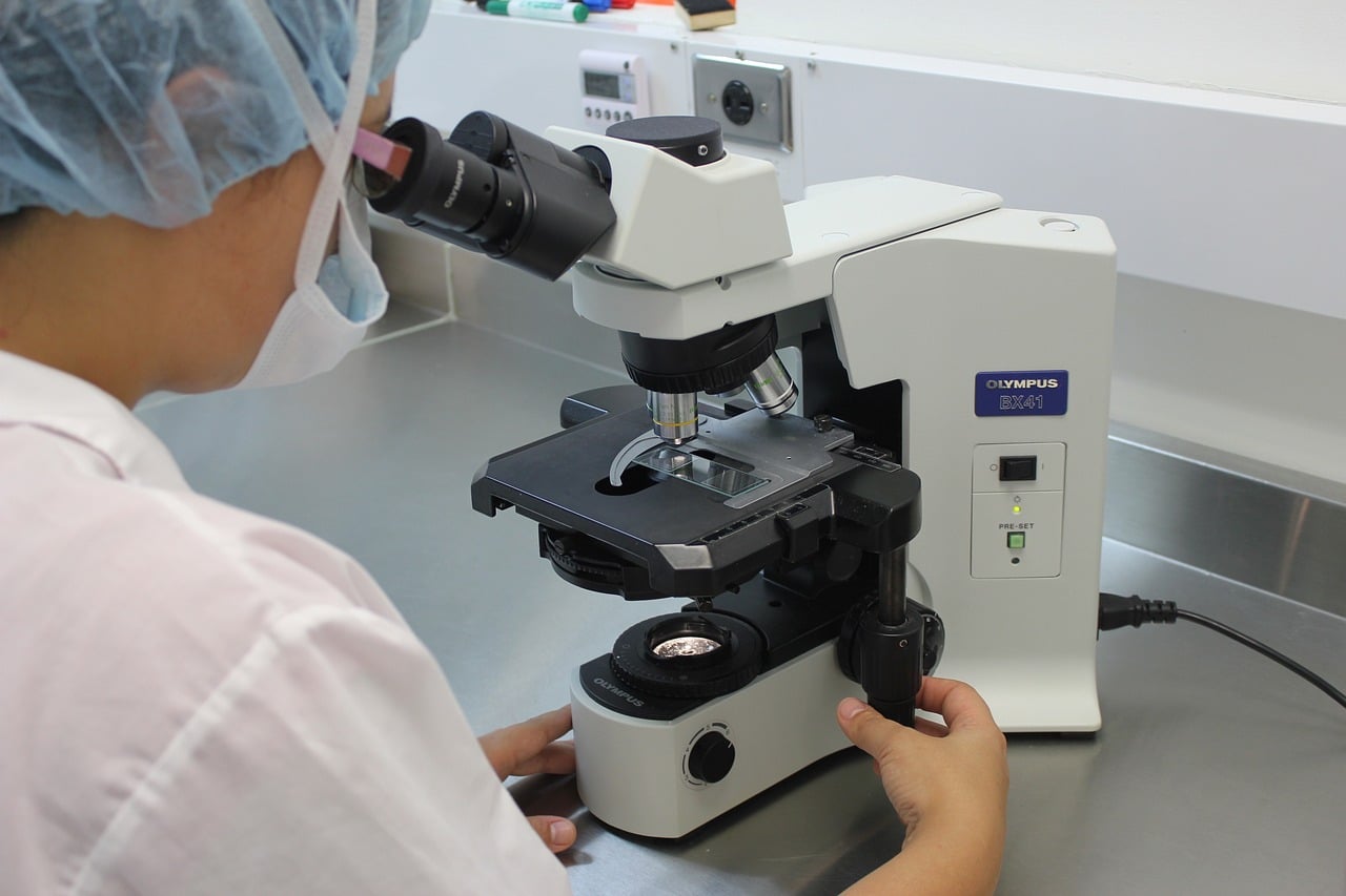 lab tech using calibrated microscope